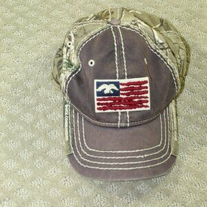 The Game Duck Commander Realtree Brown Camo Flag Factory Distressed Hat